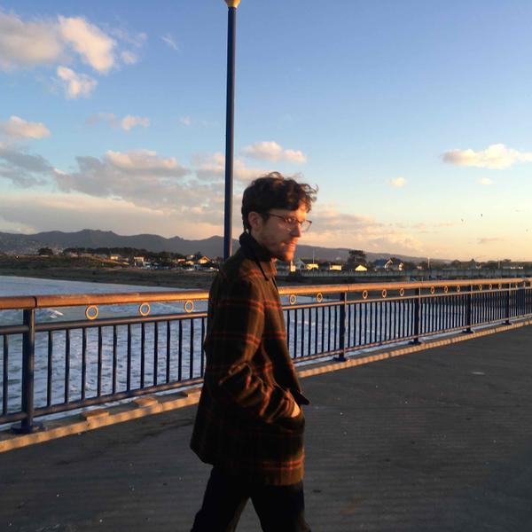 A person in the glow of evening sun standing on a wharf